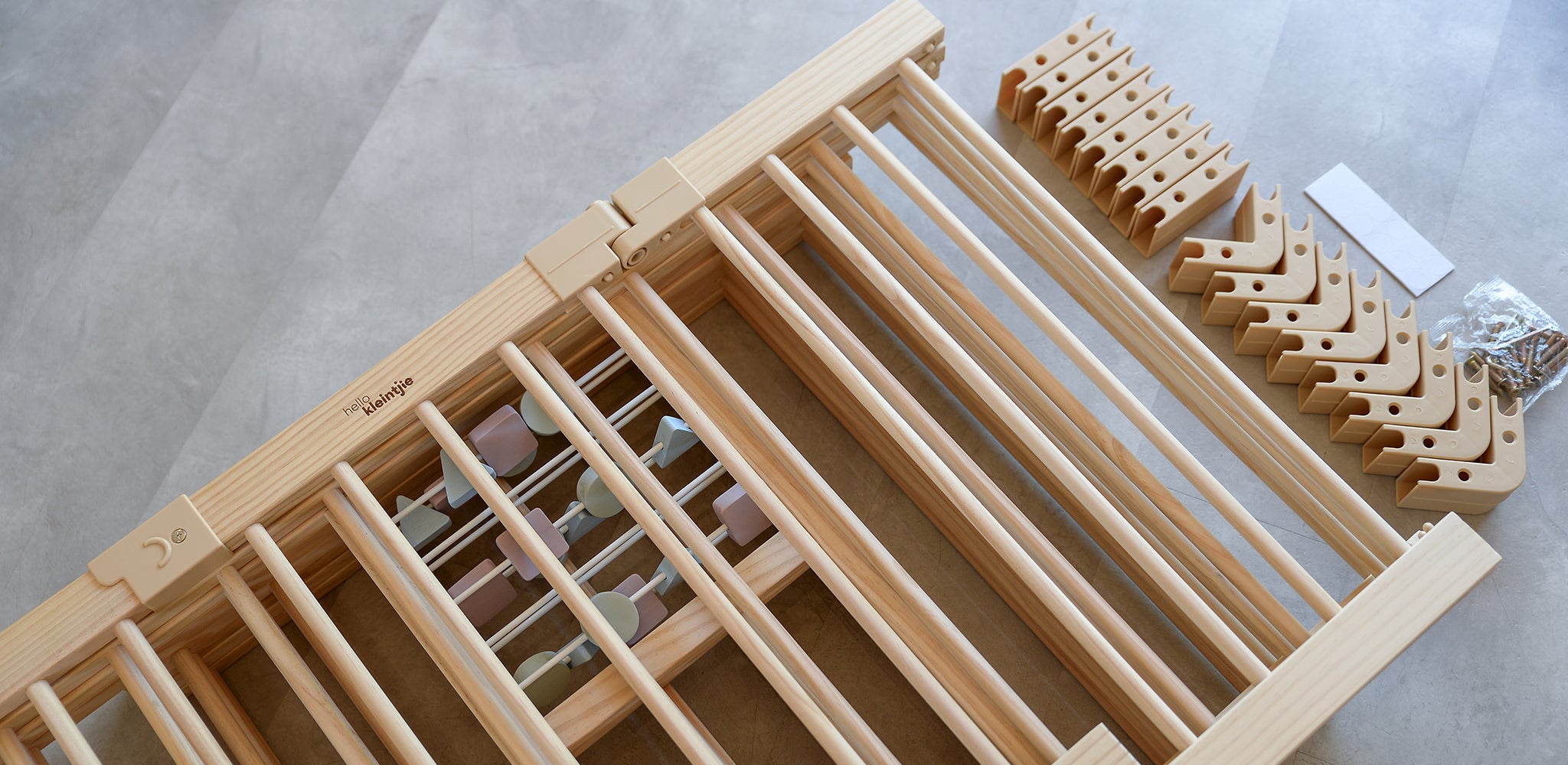 Wooden baby playpen set on a light gray surface