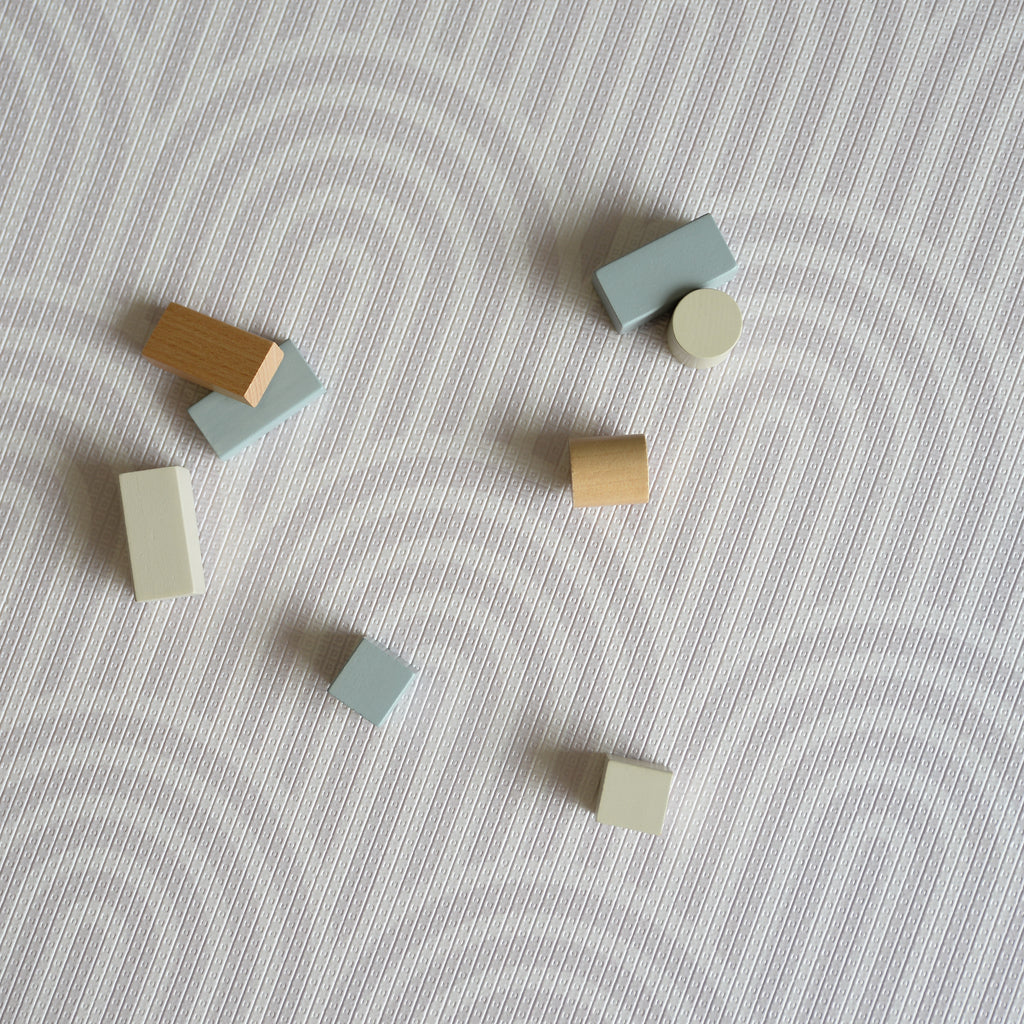 Colorful wooden blocks on a textured rainbow pattern play mat