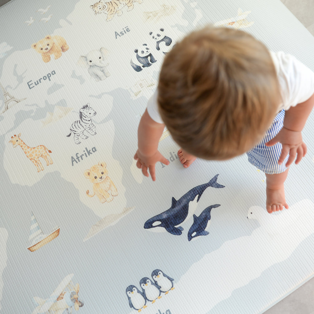 Child playing on a world map play mat