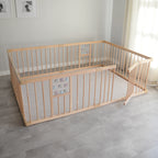 Wooden baby playpen and play mat in a room with light gray walls and flooring.