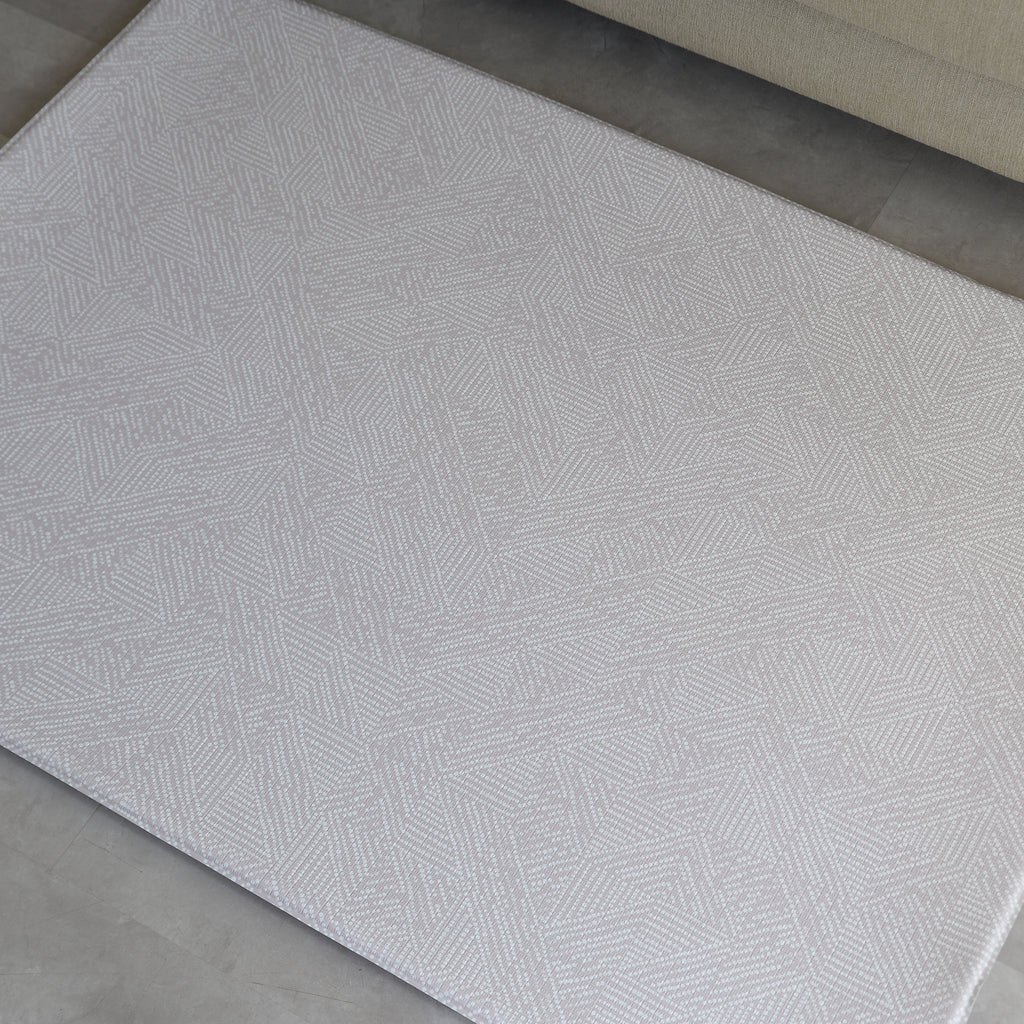 Beige dots textured play mat on a concrete floor