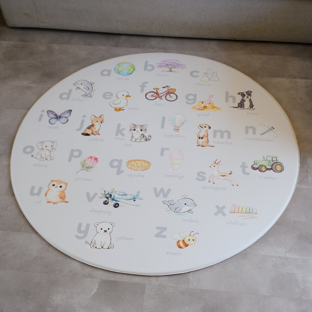 Afrikaans Alphabet play mat on a concrete floor.