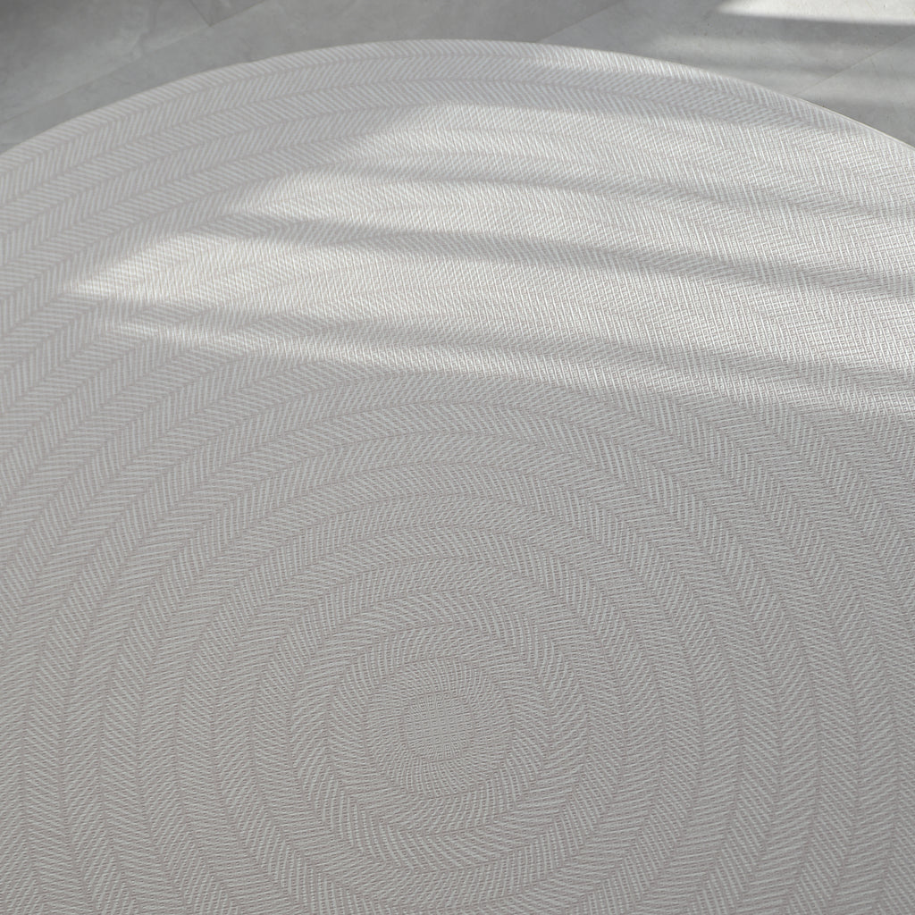 Beige play mat with a herringbone pattern on a concrete floor.