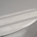 Beige play mat with a herringbone pattern on a concrete floor.