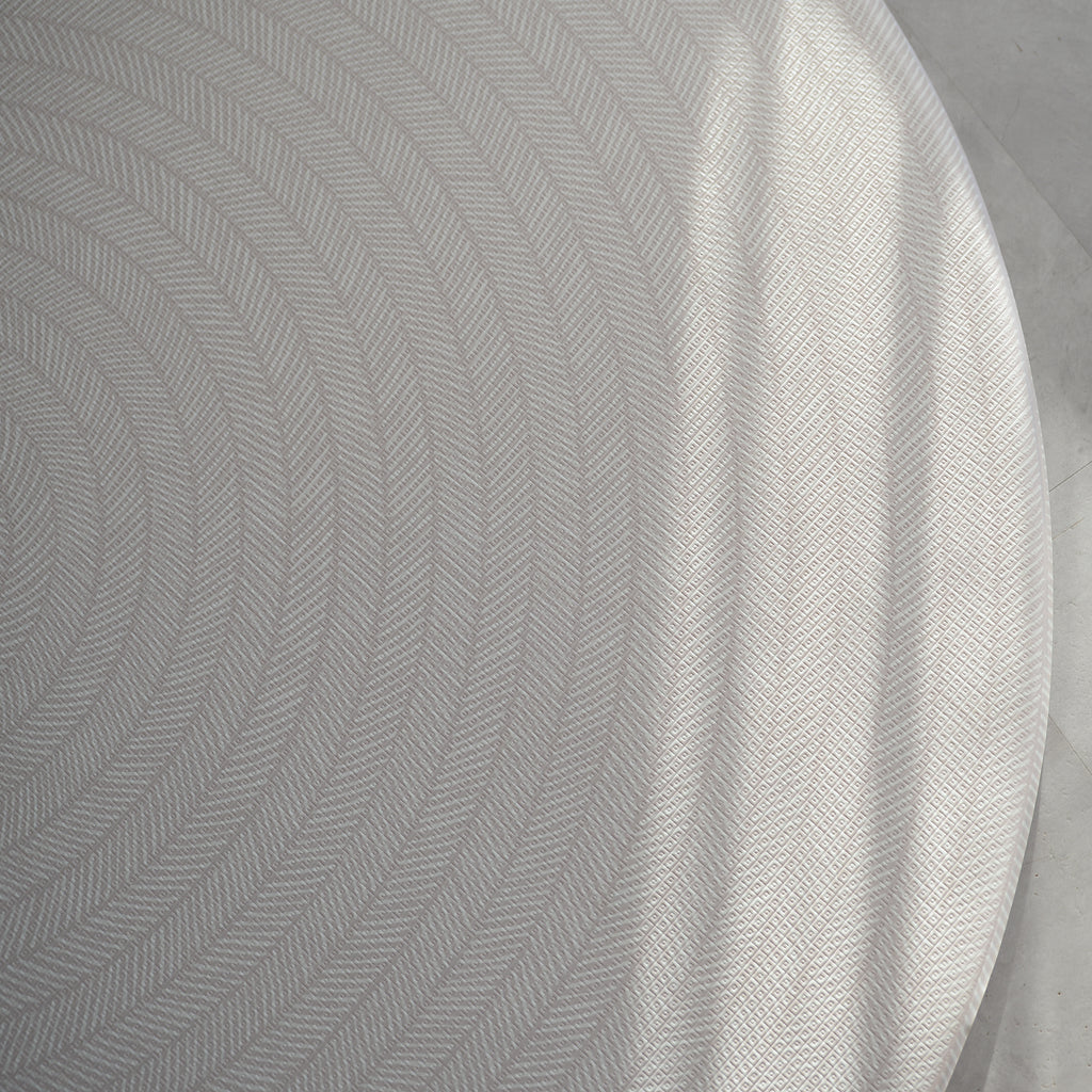 Beige play mat with a herringbone pattern on a concrete floor.