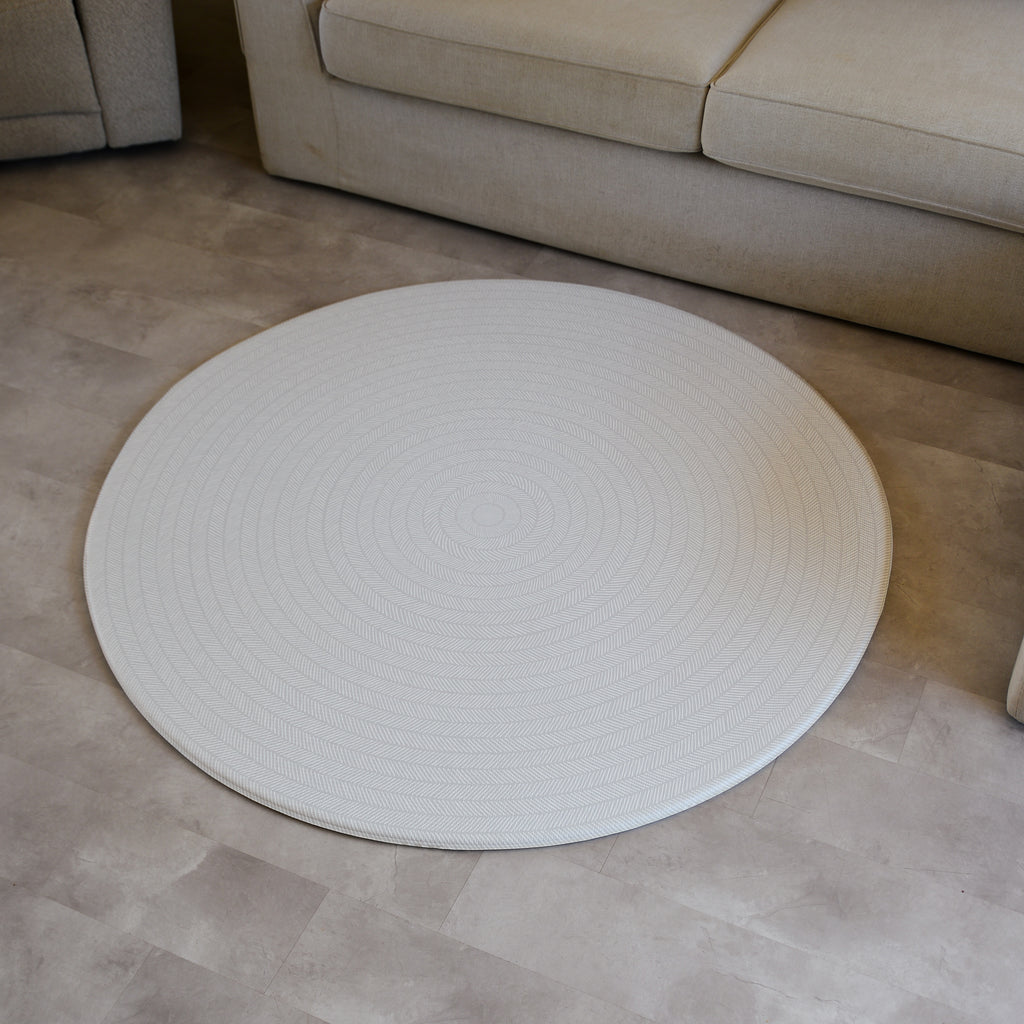 Sage play mat with a herringbone pattern on a concrete floor.