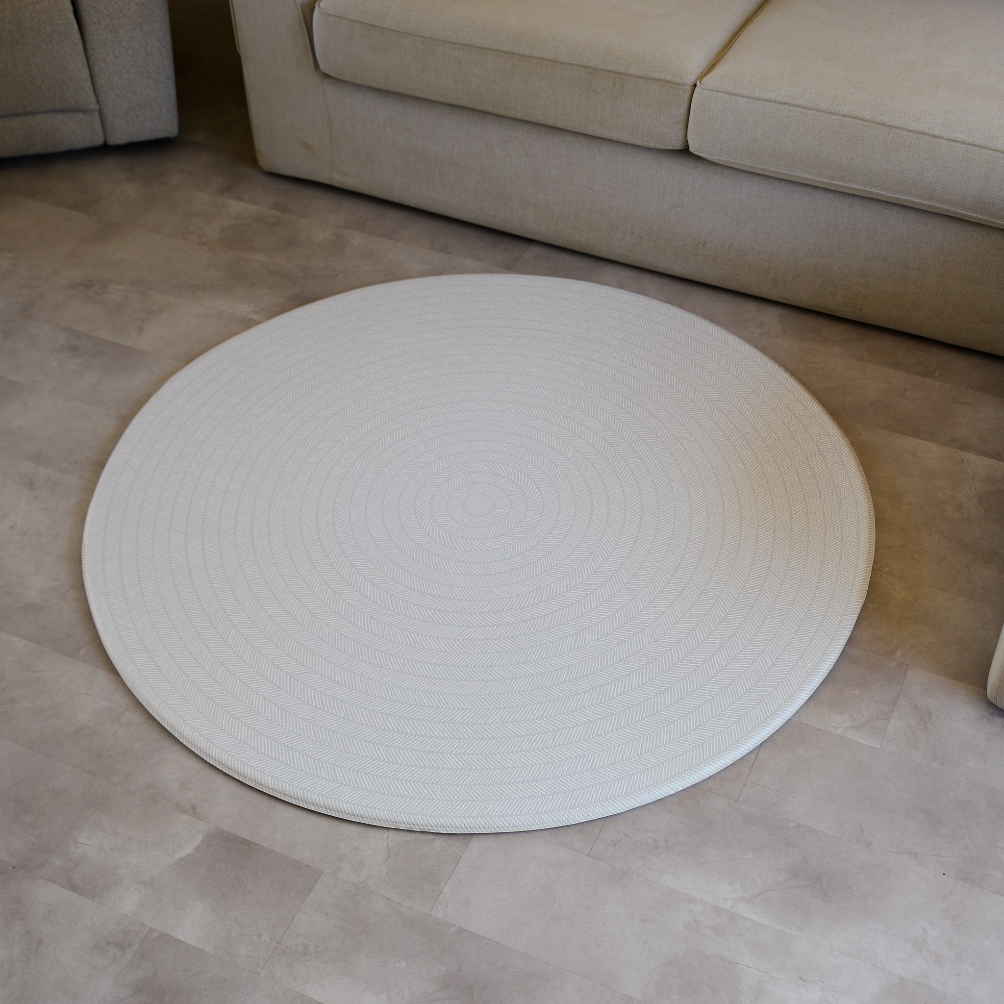 Sage play mat with a herringbone pattern on a concrete floor.