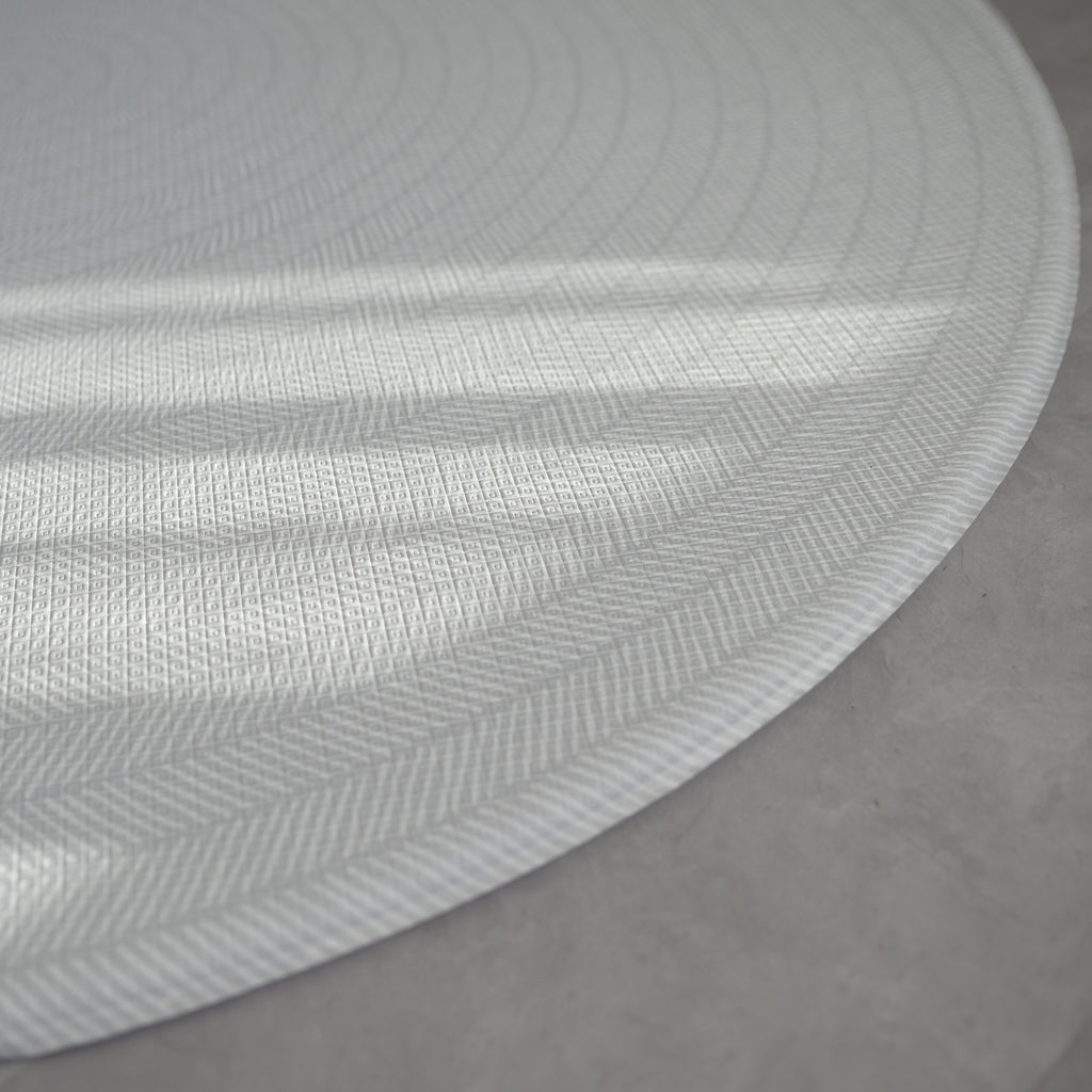 Sage play mat with a herringbone pattern on a concrete floor.